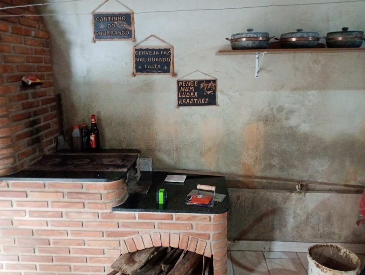 Área de churrasco pronta, com bancada e fogão a lenha