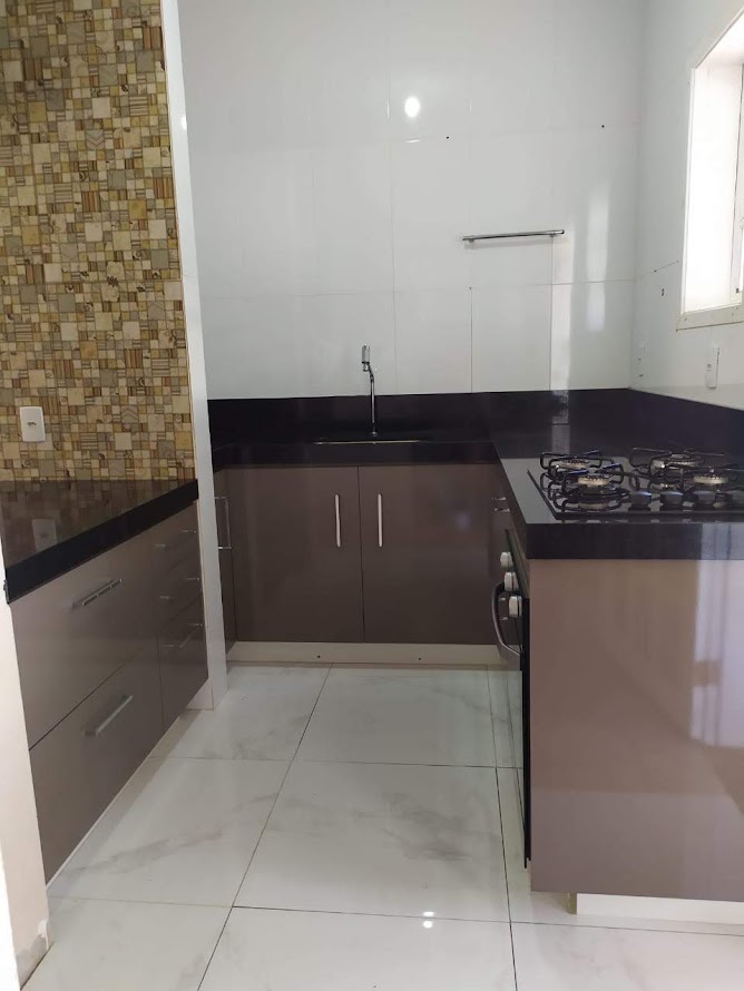 Cozinha planejada finalizada, com armários e bancada em granito